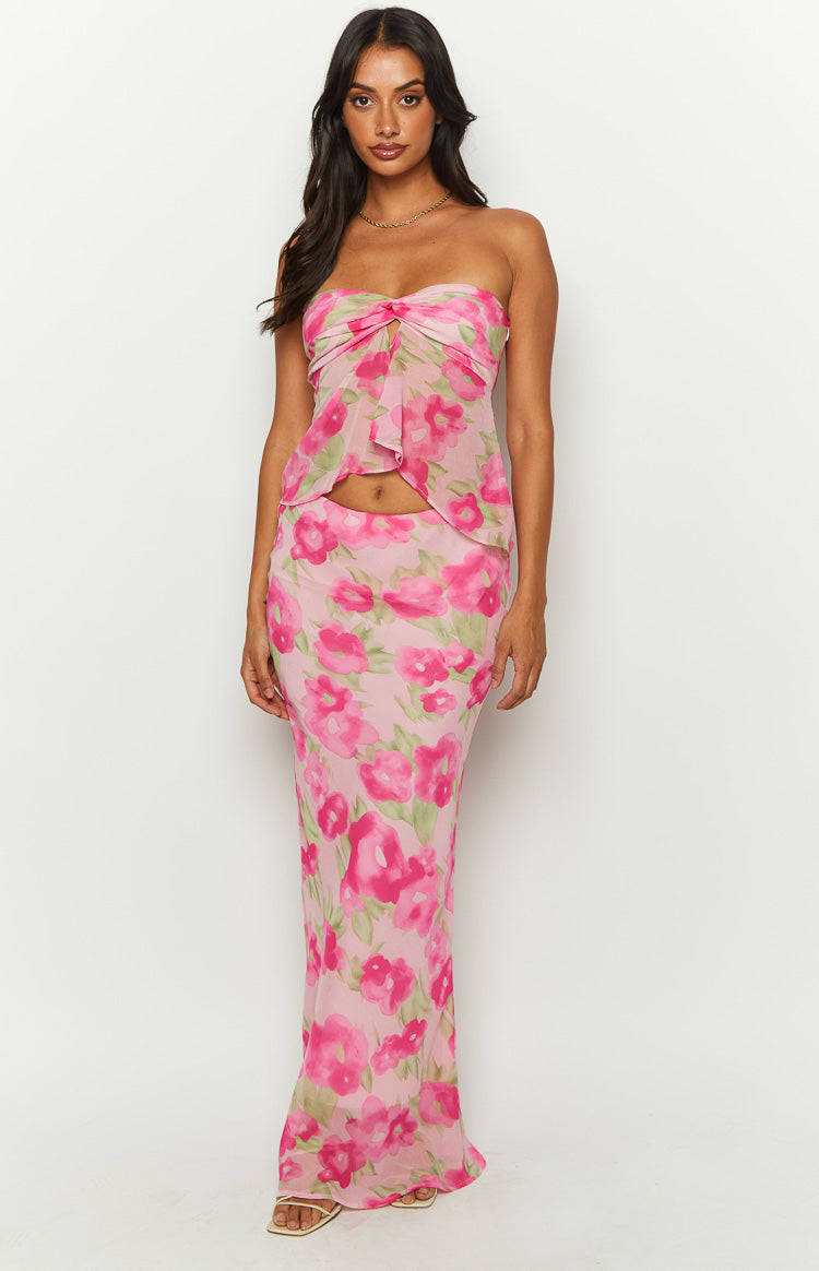 Pink floral print maxi skirt with bright fuchsia and green flowers, a fitted silhouette, and sheer, flowing fabric