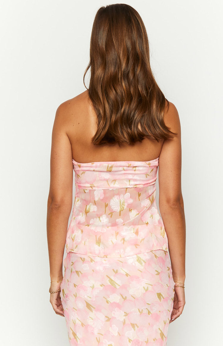 Back view of a pink floral strapless top, showing the straight neckline and sheer fabric with white and gold flowers