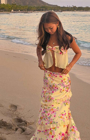 Yellow strapless top with pink and orange floral print, a front tie detail, and a flowy cropped hem