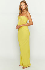 Side view of the yellow maxi skirt, showing its long, fitted silhouette and sheer hem detail