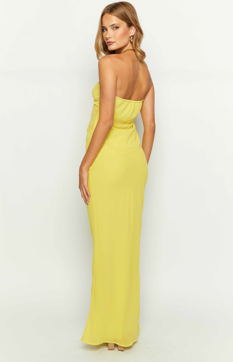 Side-back view of a bright yellow maxi skirt with a fitted waist and a long, flowing silhouette