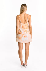 Rear view of a peach floral mini dress with a low scoop back and thin adjustable spaghetti straps