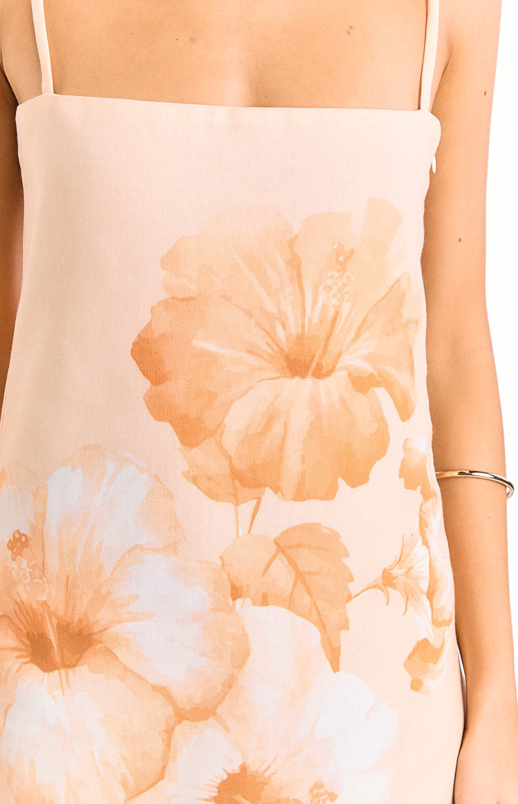 Close-up of the peach mini dress with orange and white floral print, showing the square neckline and thin spaghetti straps