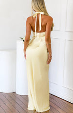 Rear view of a yellow satin halter neck maxi dress with a tie-back detail and open back
