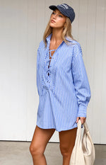 Relaxed fit blue pinstripe mini shirt dress with a collared lace-up V-neck and long sleeves