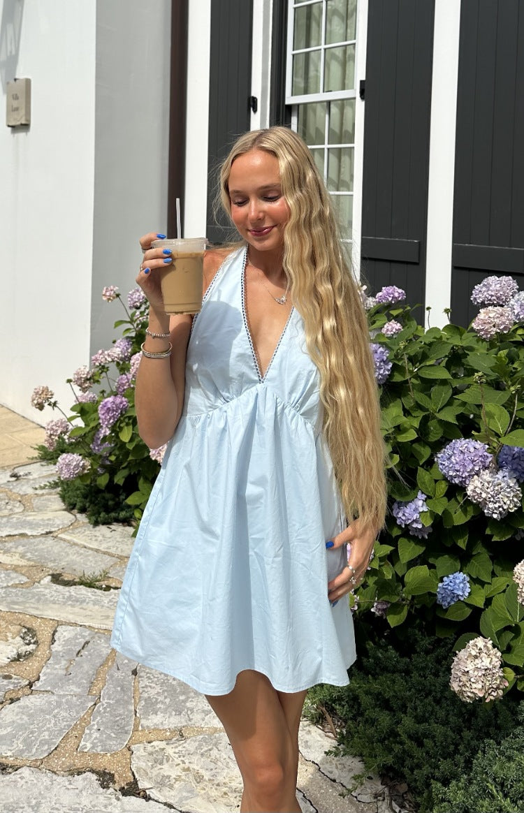 Light blue halter neck mini dress with a deep V-neckline and contrasting dark trim, gathered waist, and flowy skirt