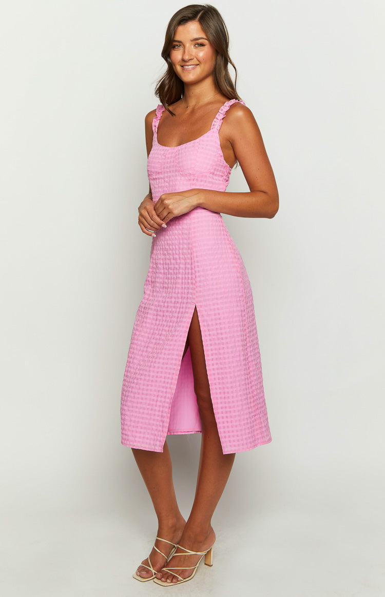 Side view of a pink gingham midi dress with ruffled shoulder straps and a high side split