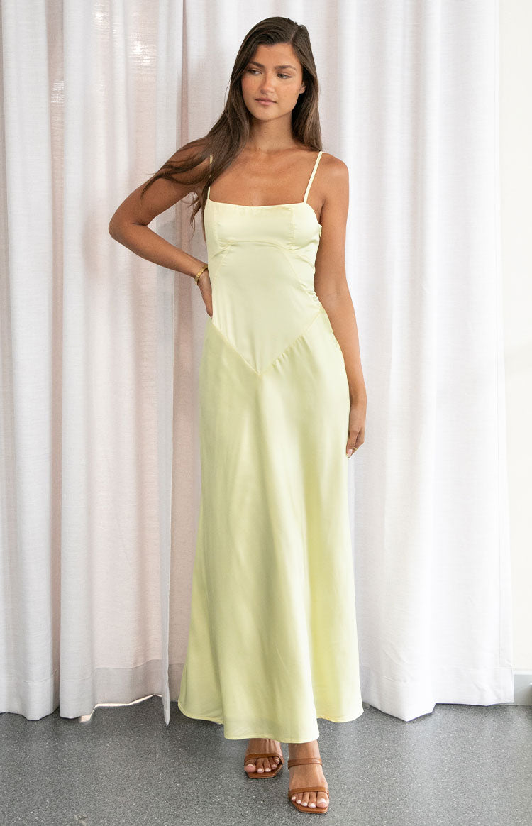 Front view of a yellow maxi dress with a square neckline, spaghetti straps, and a V-shaped bodice seam