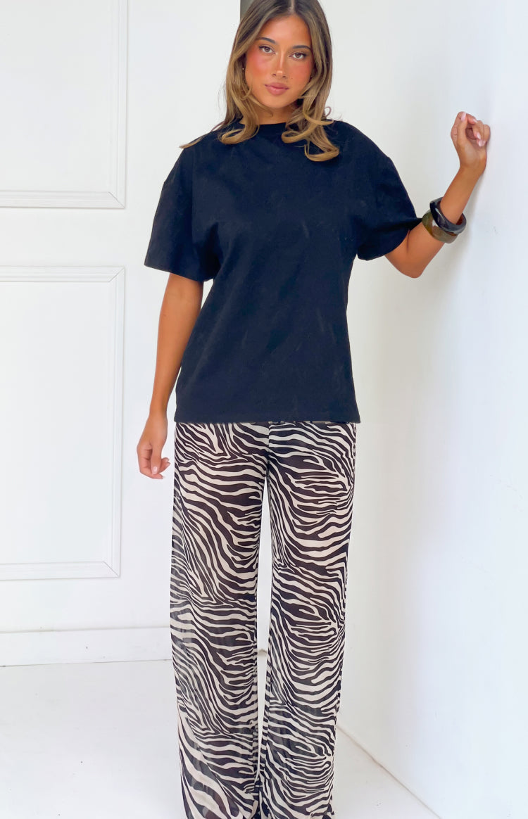 Front view of black and white sheer zebra print wide-leg pants with a relaxed fit