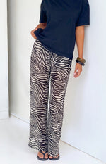 Sheer black and white zebra print wide-leg pants with a relaxed fit and flowing fabric