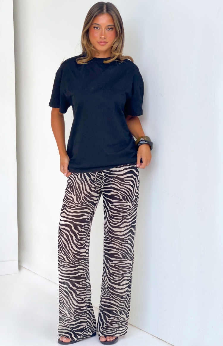 Full length front view of black sheer zebra print wide leg pants with a visible drawstring waist