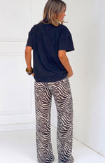 Rear-side view of black and white sheer zebra print wide-leg pants with a relaxed, flowy fit