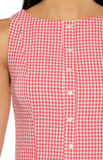 Close-up of the boat neckline and white button-front placket on a red gingham mini dress
