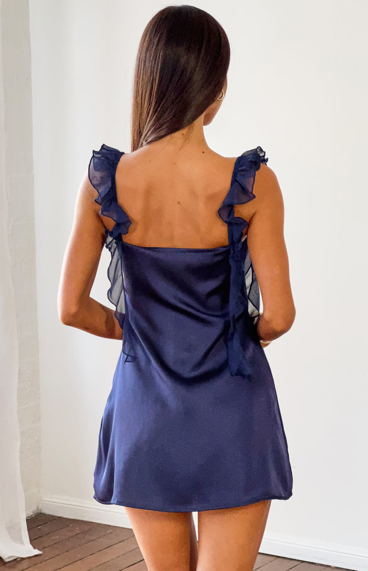 Rear view of a navy satin mini dress with a square back and sheer ruffled shoulder straps