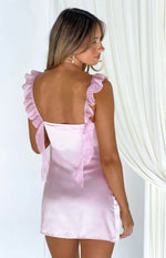 Back view of a pink satin mini dress featuring ruffled shoulder straps and a square tie-back