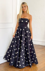 Full front view of a black polka dot satin strapless maxi dress with a fitted bodice and a full, flowing skirt