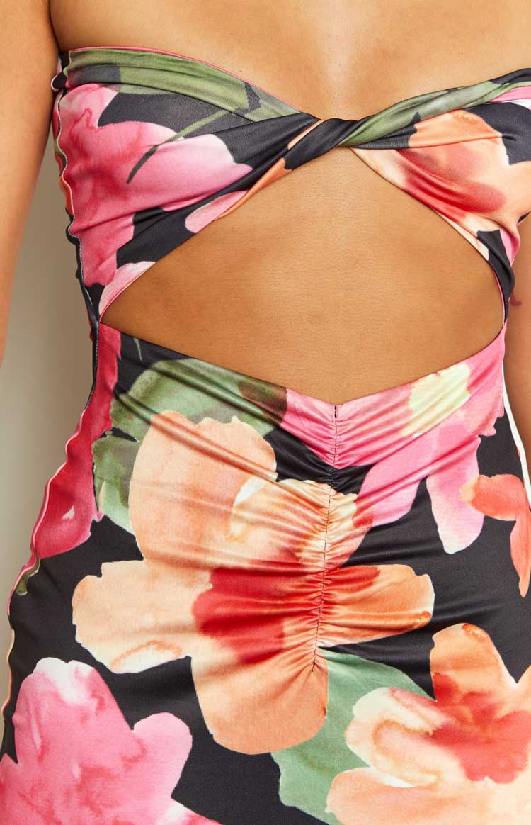 Back view of a black floral strapless midi dress with large pink, orange, and green flowers, showing the fitted silhouette