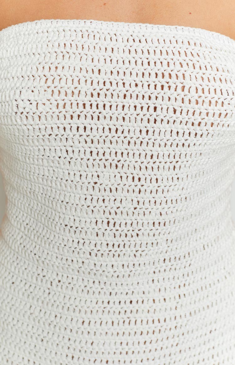 Close-up of the white knit mini dress fabric, highlighting the open crochet weave