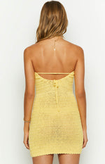 Rear view of a yellow strapless crochet knit mini dress with a tie-back and scalloped hem