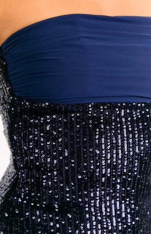 Close-up of the navy sequin fabric and the ruched strapless bust of the mini dress