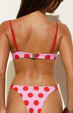 Rear view of the pink and red polka dot bikini top showing the back clasp closure and adjustable red straps