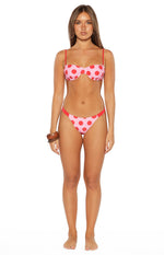 Front view of pink bikini bottoms with red polka dots, high-cut leg, and thin red side straps