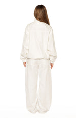 Rear view of a cream funnel neck jacket with a back yoke seam, elasticated cuffs, and a cinched hem