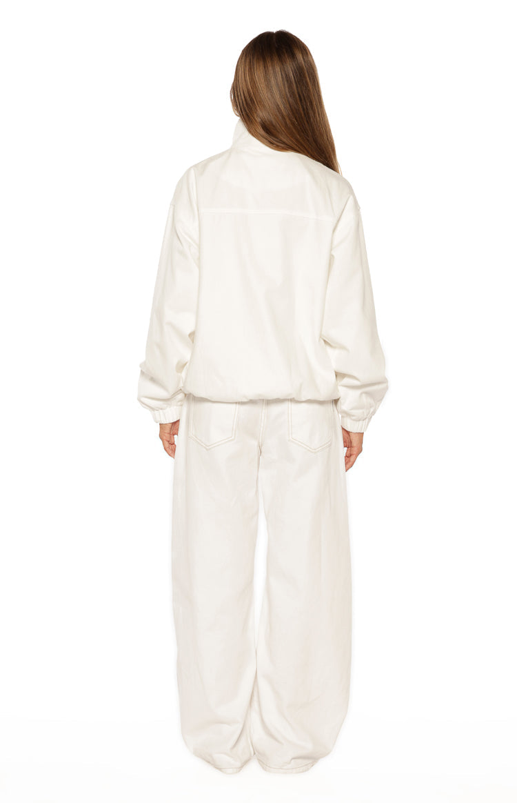 Rear view of a cream funnel neck jacket with a back yoke seam, elasticated cuffs, and a cinched hem