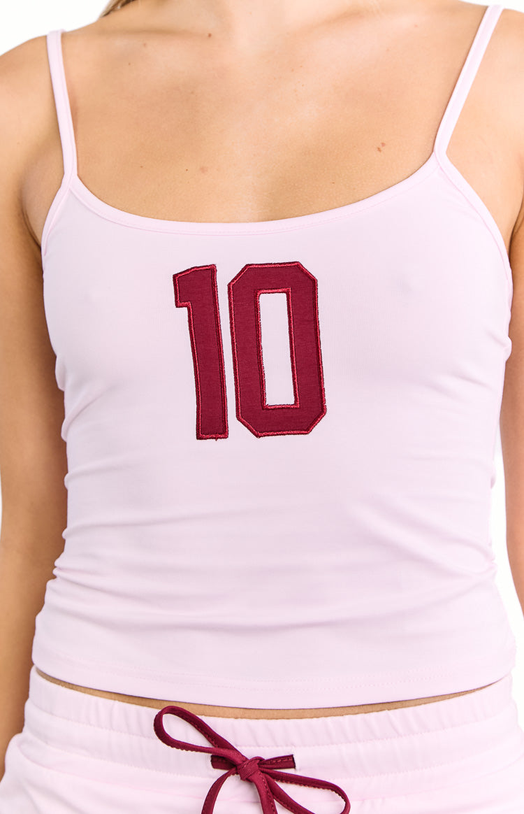 Close-up of the dark red embroidered number 10 detail on a pink jersey top