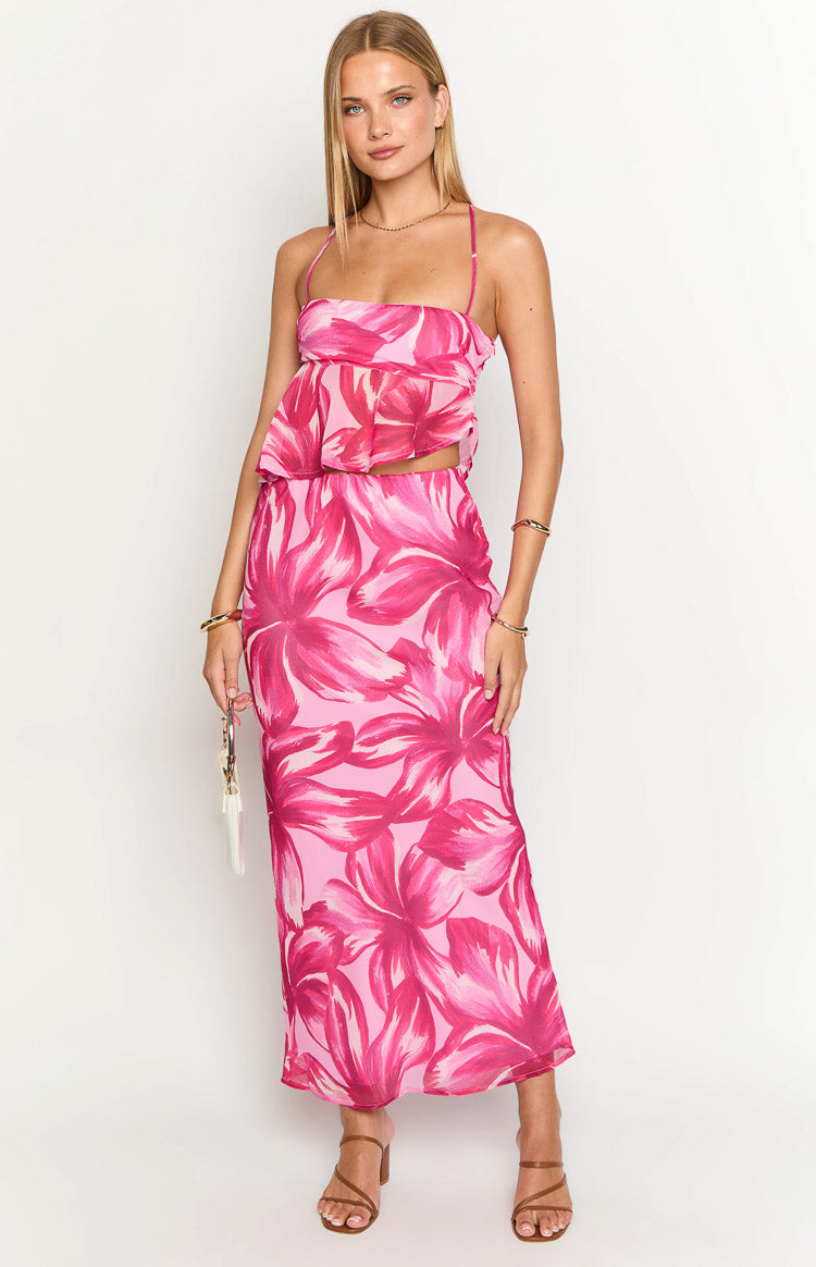 Front view of a light pink bandeau top with dark pink abstract floral print, a ruffled peplum hem and thin spaghetti straps