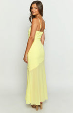 Side view of a yellow chiffon maxi dress with adjustable spaghetti straps, ruched side, and sheer asymmetrical skirt overlay