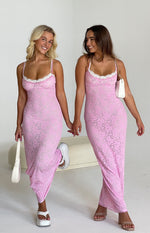 Pink lace maxi dress featuring a bodycon silhouette, delicate spaghetti straps, and white lace trim