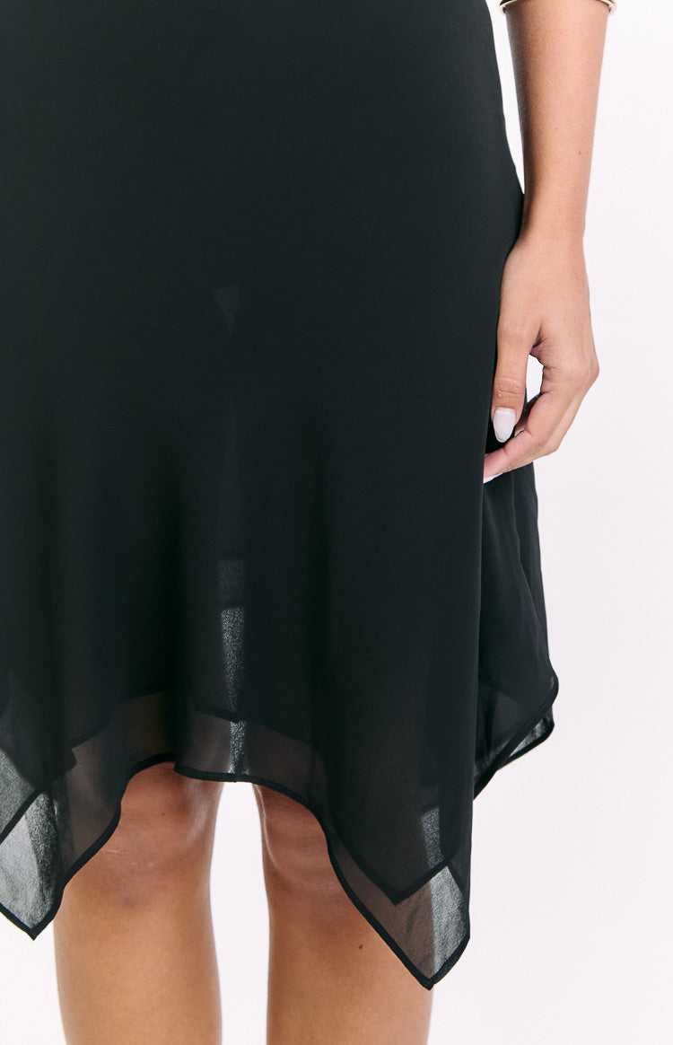 Close-up of the black hanky hem midi skirt showing the sheer layered fabric and pointed edges