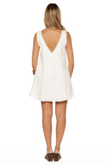 Rear view of a white cotton mini dress with a deep V-backline and delicate lace trim on the neckline and armholes