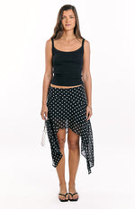 Front view of a black polka dot hanky hem midi skirt with white dots and a flowy silhouette