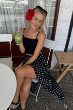 Black polka dot midi skirt with a flowy hanky hem and high slit