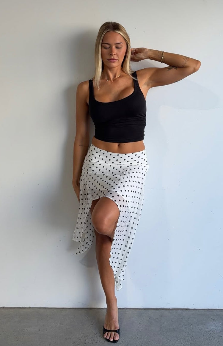 White polka dot midi skirt with a flowy hanky hem and a high leg slit