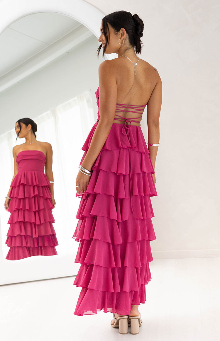 Rear view of a fuchsia strapless maxi dress with a criss-cross lace-up back and full tiered ruffles