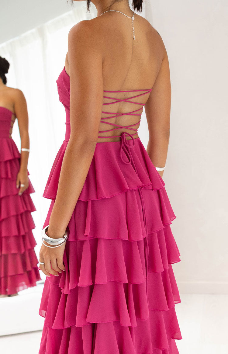 Back view of the fuchsia maxi dress with a criss-cross lace-up back and a tiered ruffle skirt