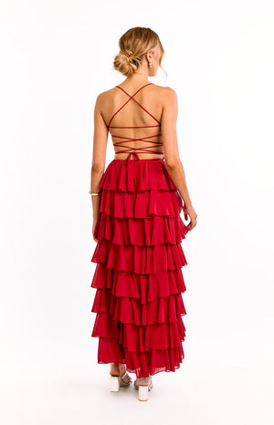 The back of a red strapless formal dress is shown on a girl. This elegant evening dress highlights the gorgeous adjustable ties details across the open back. Perfect for a graduation or black tie event.