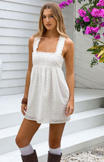 White broderie anglaise mini dress with a square neckline and ruffled lace trim on the wide straps