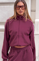 Burgundy track jacket with high collar, full zip front, and elasticated cropped hem showing matching pants
