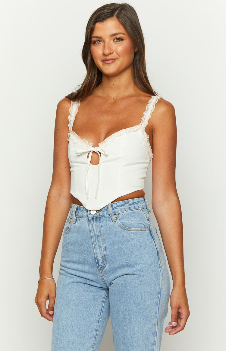 Close-up of the white corset top showing the lace-trimmed sweetheart neckline and front tie detail