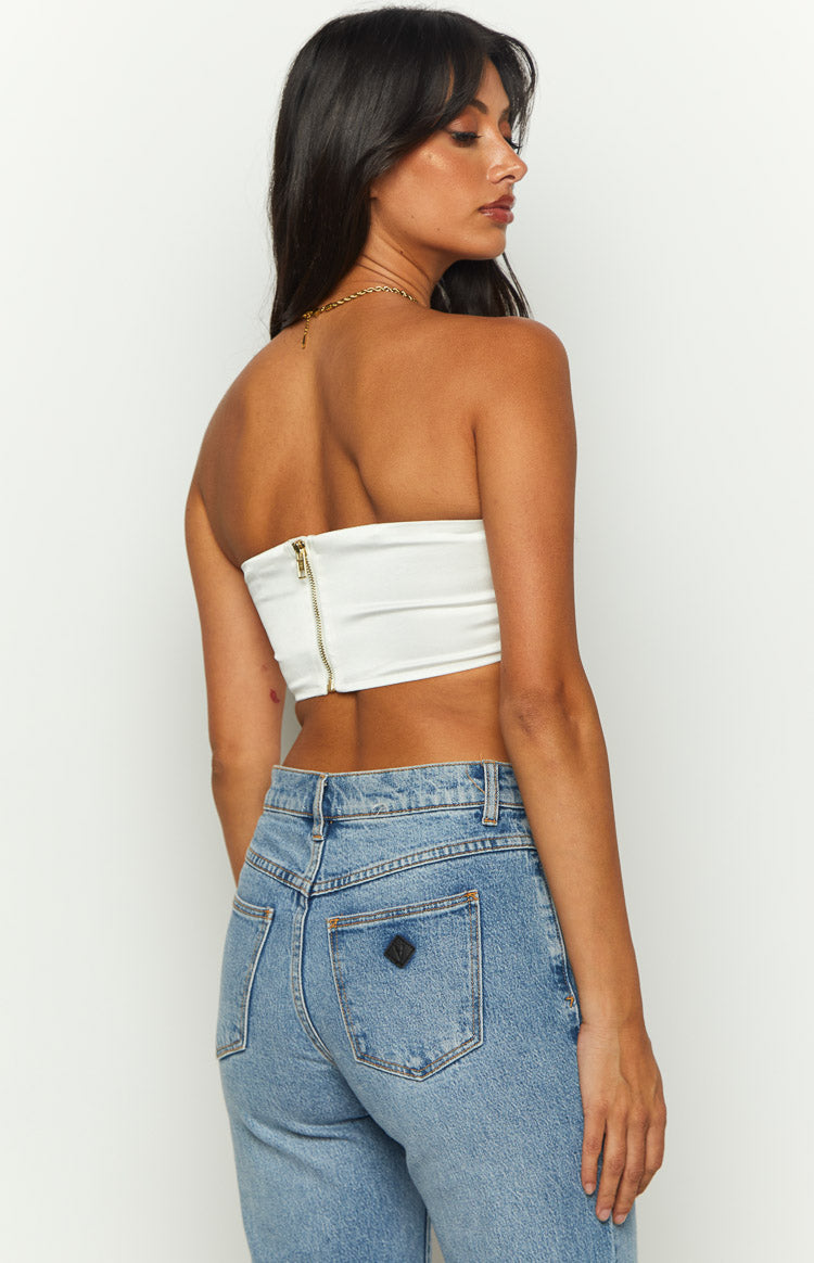 Rear view of the white strapless bandeau crop with a gold zipper closure at the back
