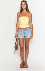 Light wash denim shorts with a low-rise waist, distressed details, and cuffed hems