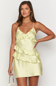 Ruffled V-neckline and tiered ruffles on the bodice and skirt of a yellow satin mini dress