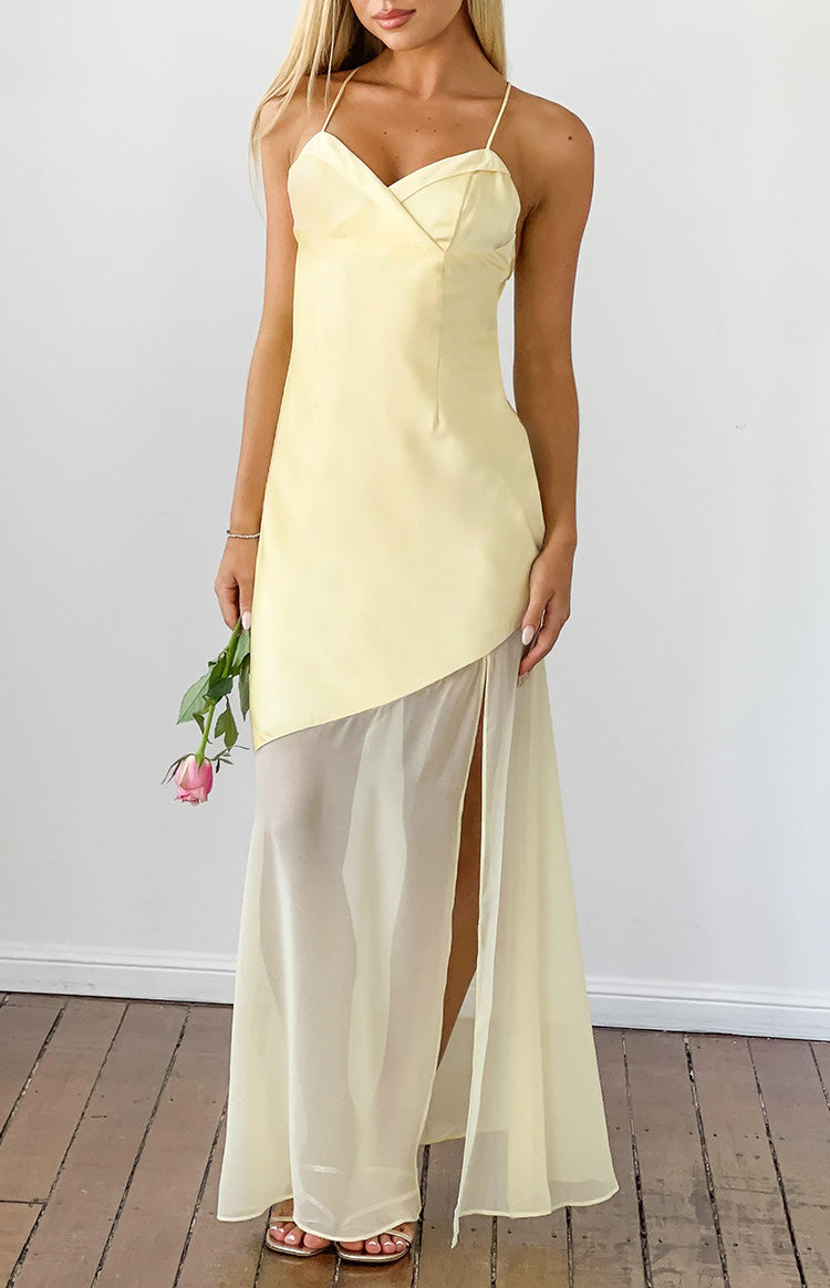 Front view of a yellow satin maxi dress featuring a V-neck bodice, thin spaghetti straps, and a sheer chiffon skirt with a hi