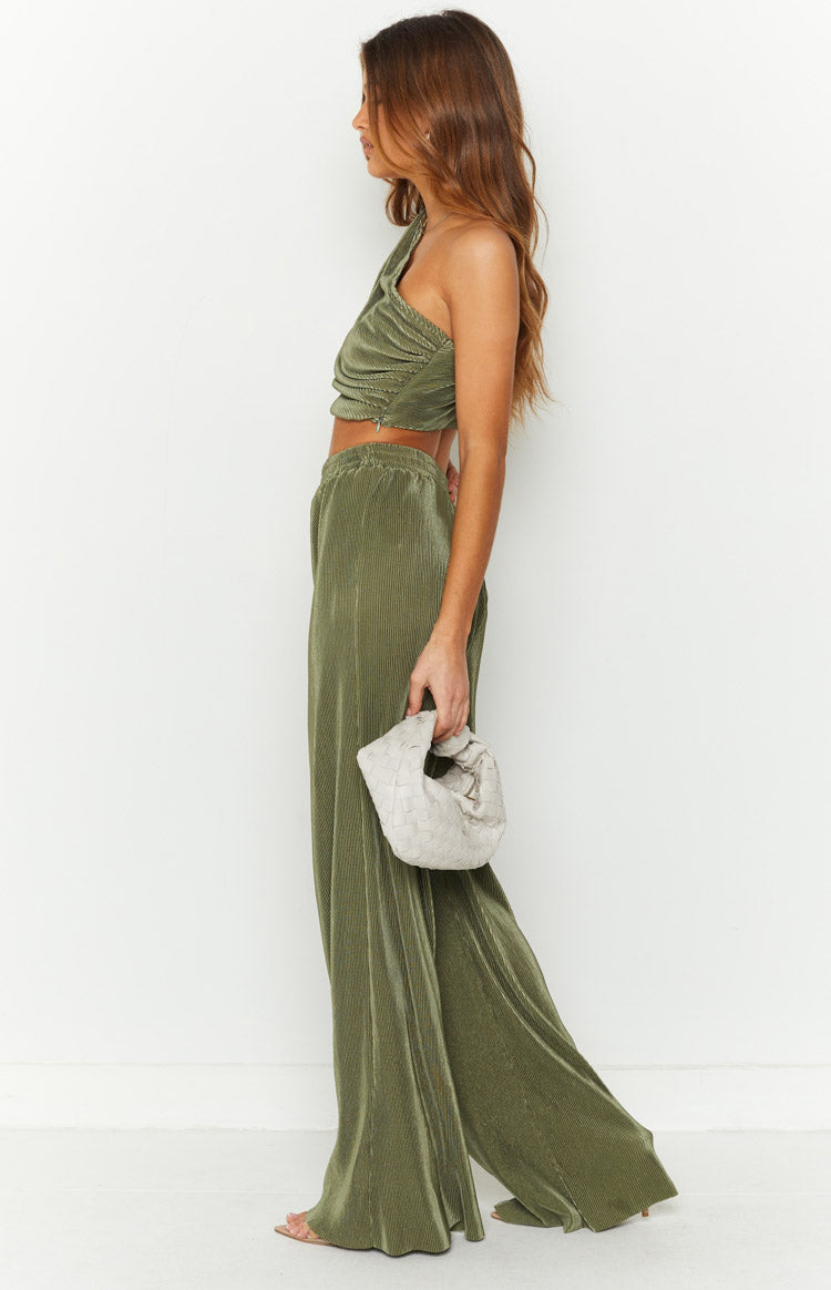 Side view of the full length of khaki green pleated wide-leg pants with an elasticated waistband