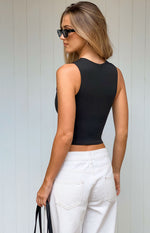 Side view of a black fitted tank top with a high scoop back and cropped hem