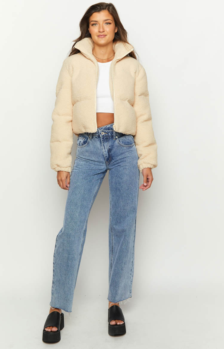 Beige teddy puffer jacket with a high stand collar, textured fabric, and partially unzipped front